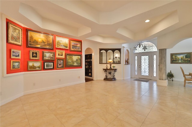 tiled entrance foyer with a tray ceiling