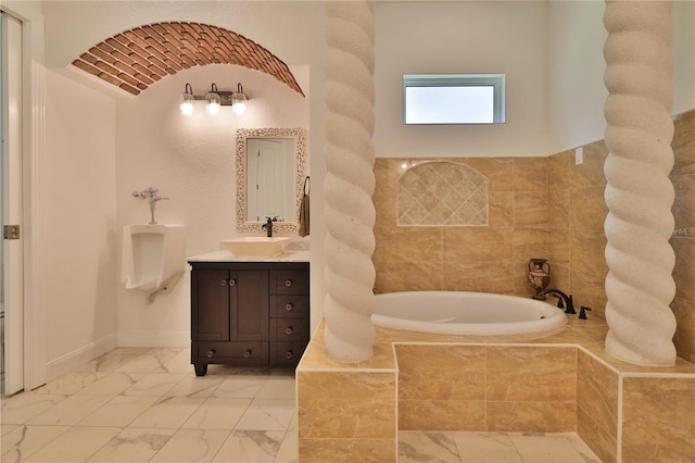 bathroom with vanity and tiled tub