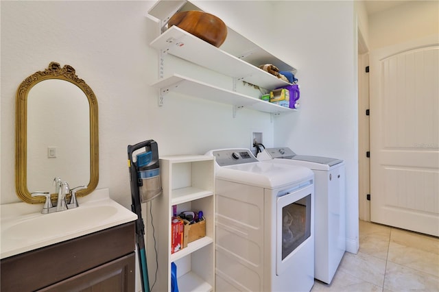 clothes washing area with washing machine and clothes dryer, light tile patterned flooring, and sink