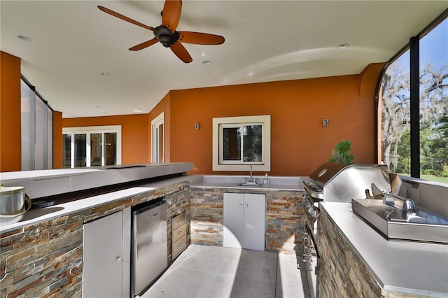 view of patio with area for grilling, ceiling fan, sink, and exterior kitchen