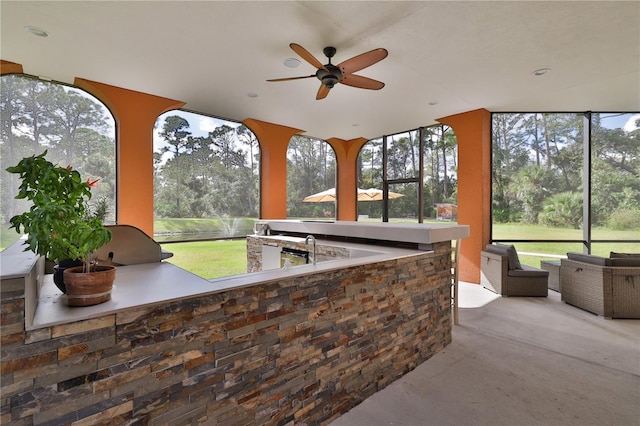 sunroom / solarium featuring ceiling fan