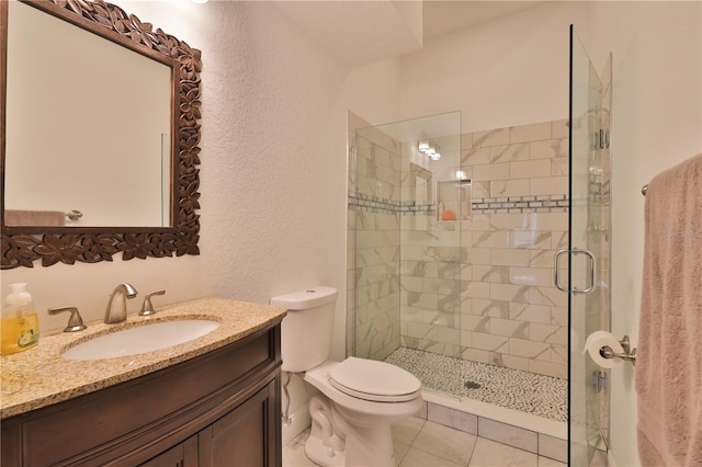 bathroom featuring vanity, tile patterned flooring, toilet, and an enclosed shower