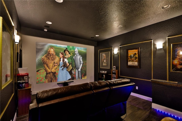 cinema room featuring a textured ceiling and dark hardwood / wood-style floors