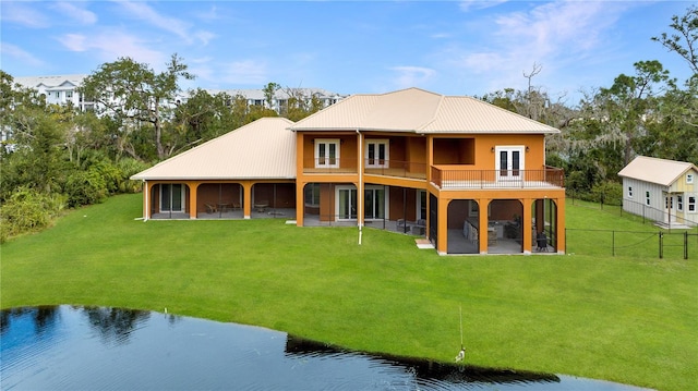 rear view of property featuring a patio area, a water view, and a lawn