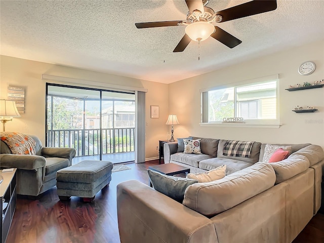 living room featuring ceiling fan, a textured ceiling, and dark hardwood / wood-style flooring