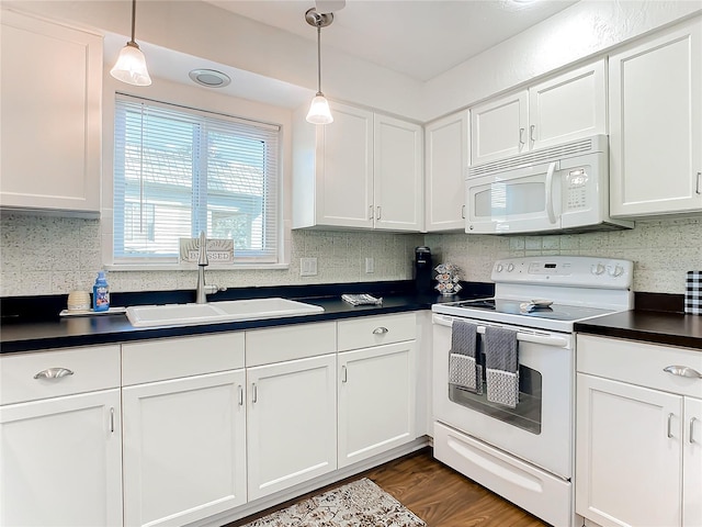 kitchen with decorative light fixtures, sink, white appliances, and dark wood-type flooring