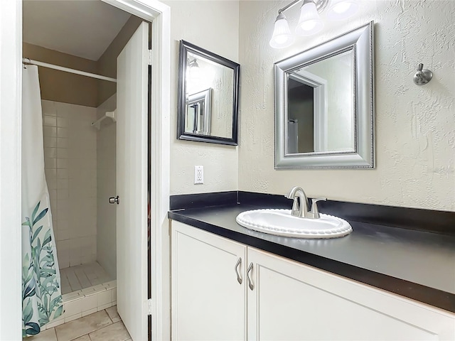 bathroom with a shower with shower curtain, tile patterned floors, and vanity