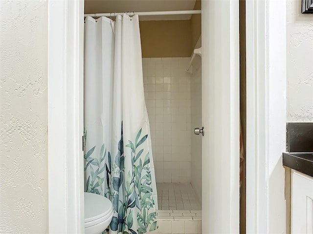 bathroom featuring a shower with curtain and toilet