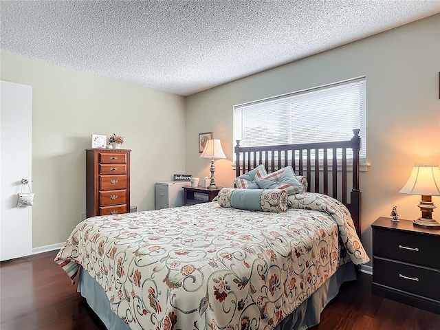 bedroom featuring a textured ceiling and dark hardwood / wood-style flooring