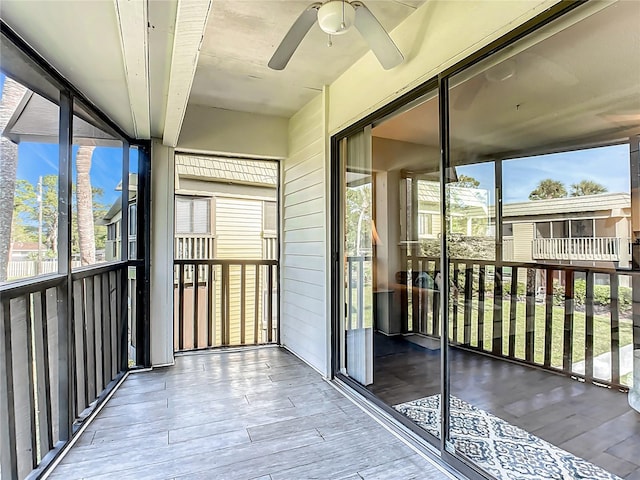 unfurnished sunroom with ceiling fan