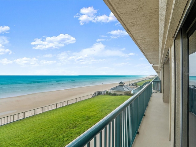 balcony featuring a view of the beach and a water view