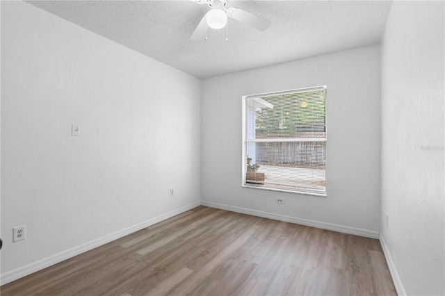 spare room featuring ceiling fan, a textured ceiling, and light wood-type flooring