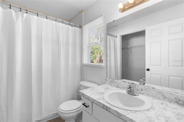 bathroom featuring vanity, toilet, and a textured ceiling