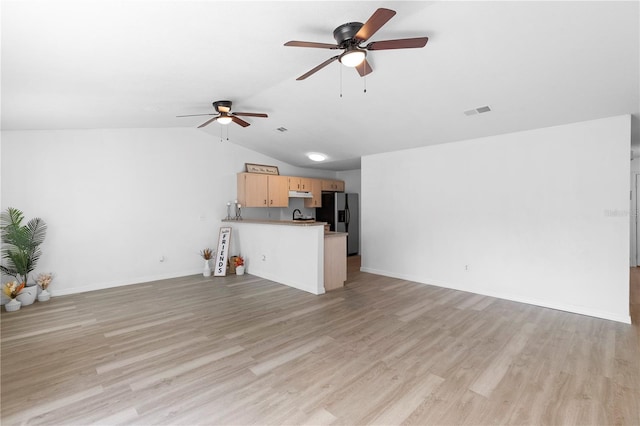 unfurnished living room with light hardwood / wood-style floors, ceiling fan, sink, and vaulted ceiling