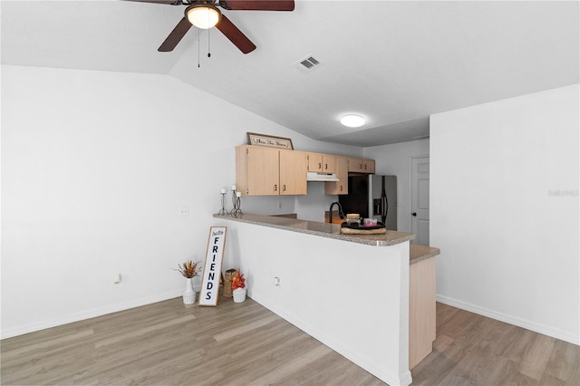 kitchen with light hardwood / wood-style floors, kitchen peninsula, light brown cabinetry, lofted ceiling, and stainless steel fridge with ice dispenser