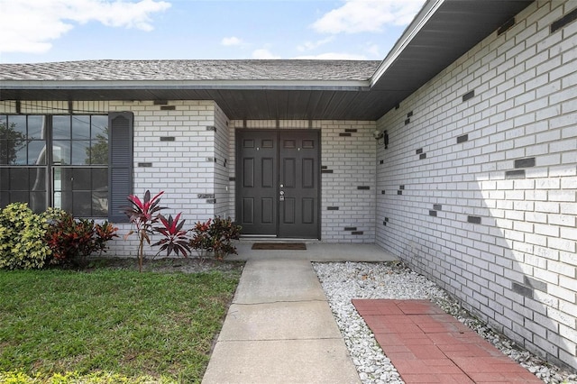 doorway to property featuring a lawn