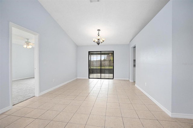 unfurnished room featuring light tile patterned floors, ceiling fan with notable chandelier, and lofted ceiling