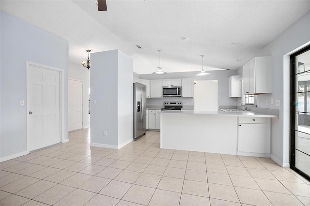 kitchen featuring ceiling fan with notable chandelier, kitchen peninsula, vaulted ceiling, appliances with stainless steel finishes, and white cabinetry