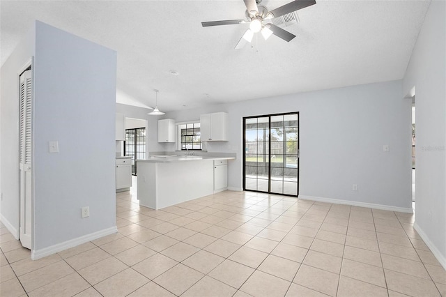 unfurnished living room featuring light tile patterned floors, a textured ceiling, ceiling fan, and lofted ceiling