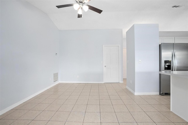 tiled empty room featuring vaulted ceiling and ceiling fan