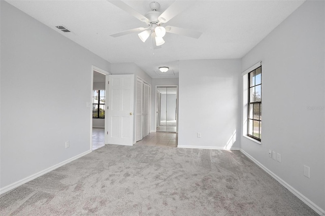 carpeted empty room featuring ceiling fan