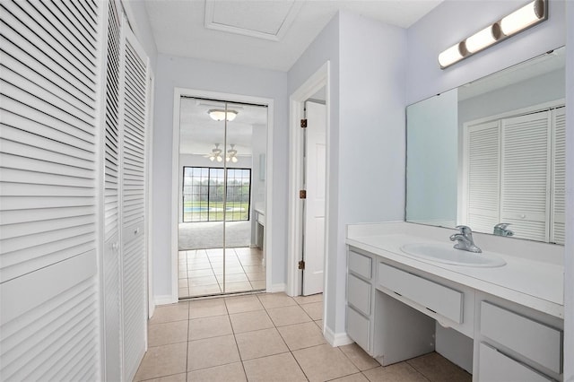 bathroom featuring tile patterned flooring, vanity, and a notable chandelier