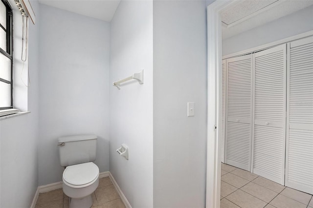 bathroom with a wealth of natural light, tile patterned flooring, and toilet