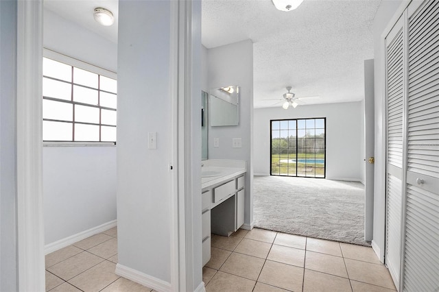 bathroom featuring tile patterned floors, ceiling fan, sink, and a textured ceiling