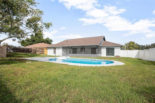 rear view of property featuring a lawn and a sunroom