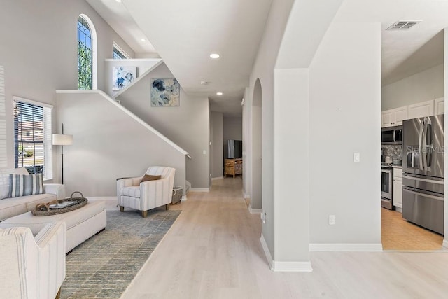 living room with light wood-type flooring and plenty of natural light