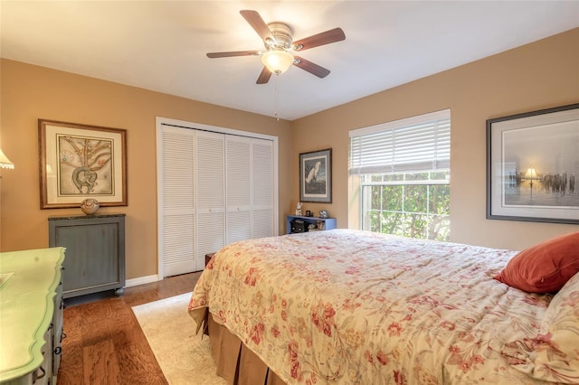 bedroom with dark wood-type flooring, a closet, and ceiling fan