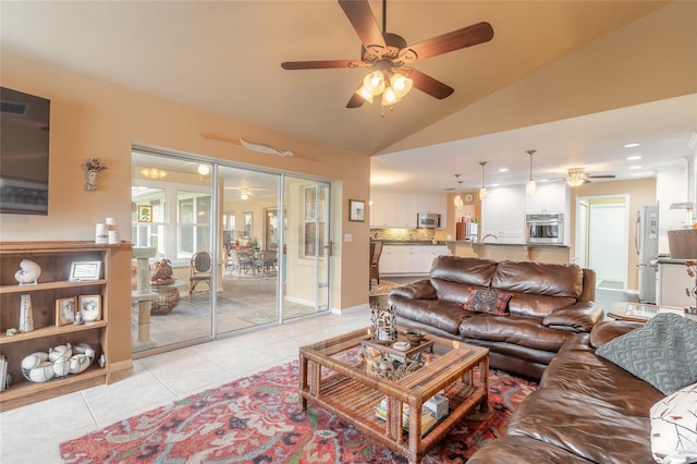 living room featuring lofted ceiling, light tile patterned floors, and ceiling fan