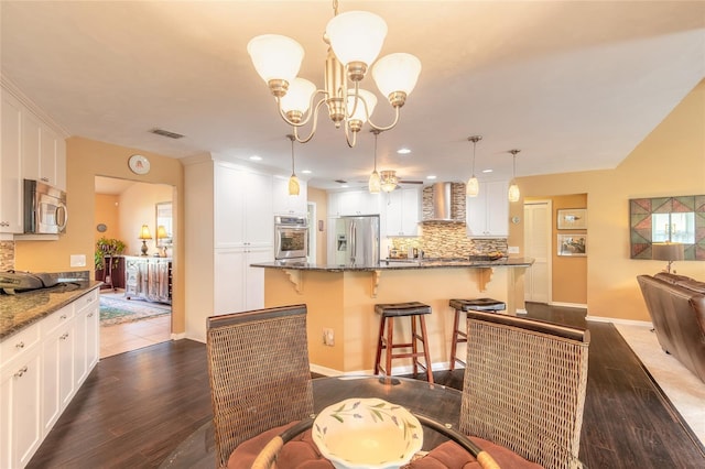 dining area with dark wood-type flooring and ceiling fan with notable chandelier