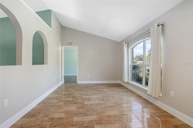 empty room featuring light hardwood / wood-style floors and vaulted ceiling