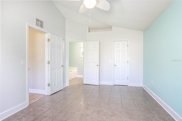 unfurnished bedroom with lofted ceiling, ceiling fan, light tile patterned floors, a textured ceiling, and a closet