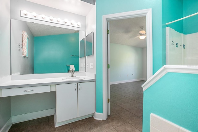 bathroom featuring a tile shower, ceiling fan, tile patterned flooring, a textured ceiling, and vanity