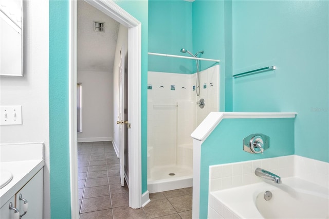 bathroom featuring tile patterned flooring, vanity, independent shower and bath, and a textured ceiling