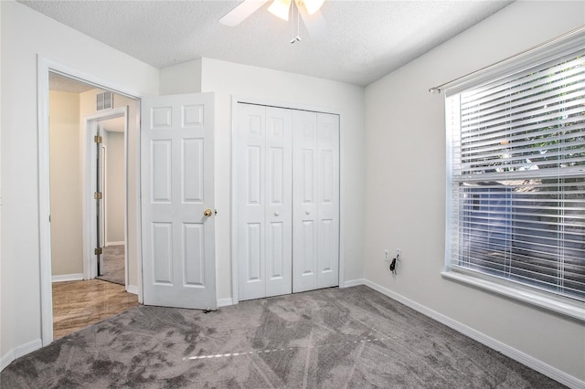 unfurnished bedroom featuring ceiling fan, a closet, carpet, and a textured ceiling