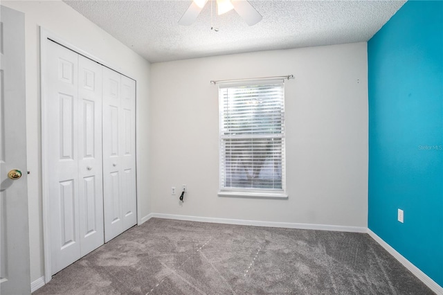 unfurnished bedroom with ceiling fan, a closet, light carpet, and a textured ceiling