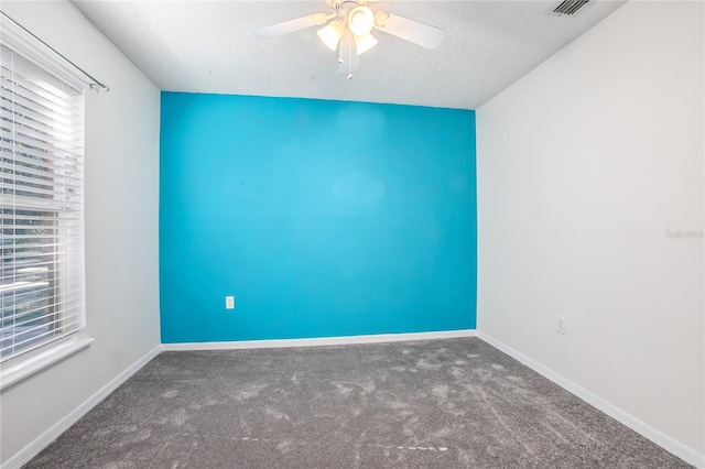 carpeted empty room featuring ceiling fan and a textured ceiling