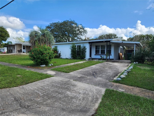 ranch-style house featuring a carport and a front lawn