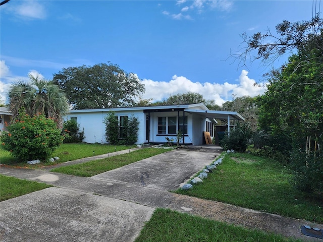 ranch-style house featuring a front lawn and a carport