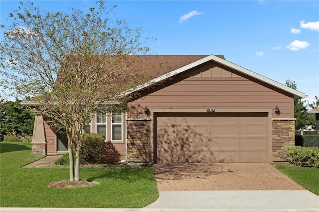 ranch-style house featuring a garage and a front lawn