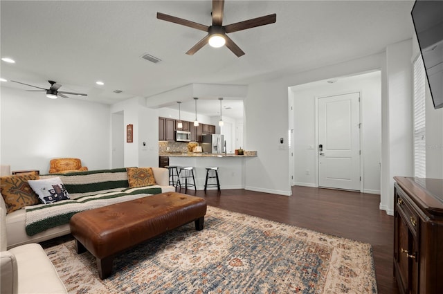 living room featuring dark hardwood / wood-style floors and ceiling fan