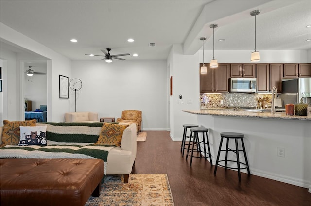 living room featuring ceiling fan and dark wood-type flooring