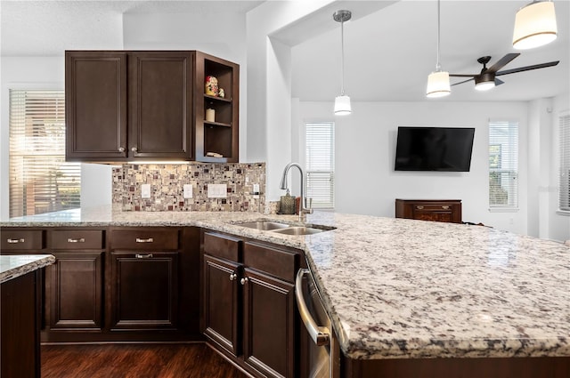 kitchen featuring dishwasher, sink, light stone counters, tasteful backsplash, and dark hardwood / wood-style flooring