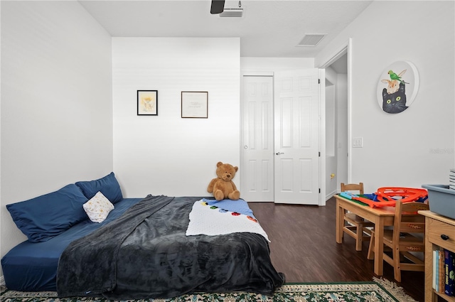 bedroom with a closet and dark wood-type flooring