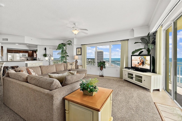 living room featuring ceiling fan, light carpet, and crown molding