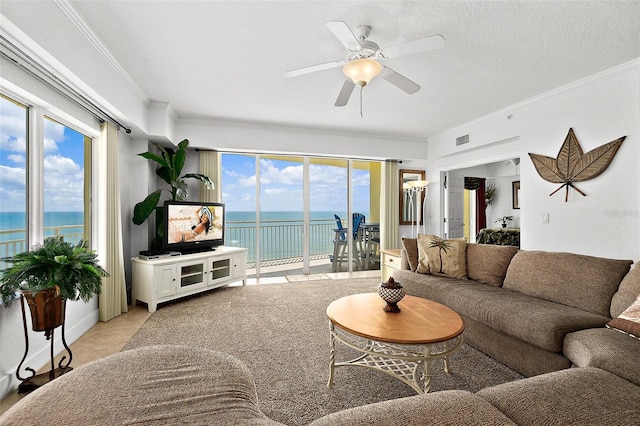 living room featuring a textured ceiling, ceiling fan, and crown molding