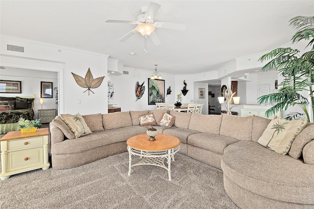 carpeted living room with ceiling fan and crown molding